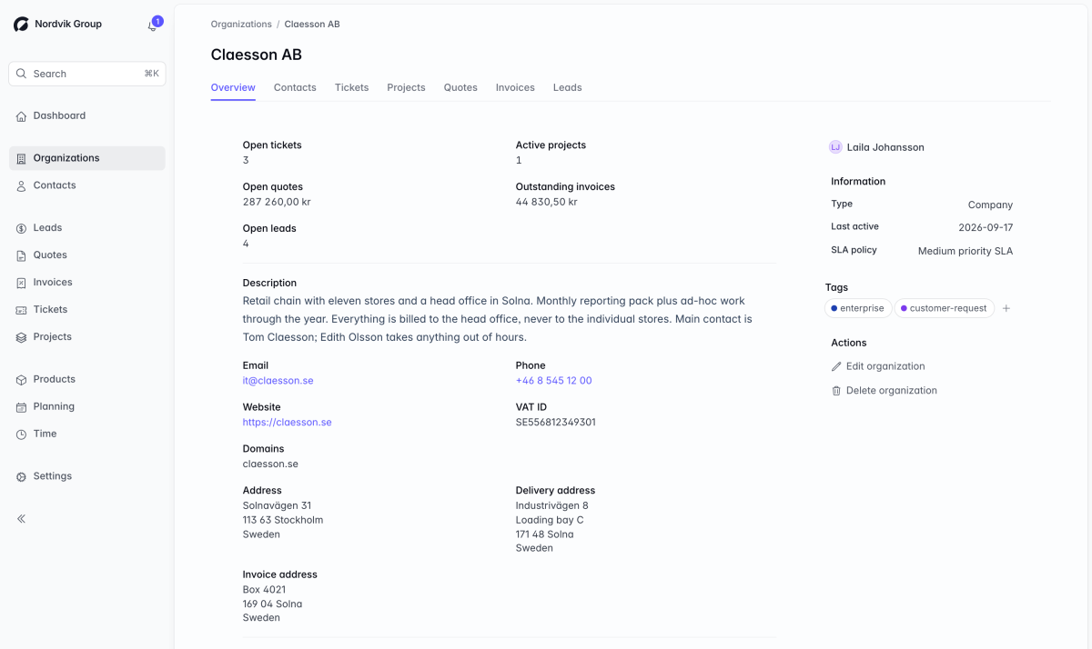 A Corker organisation record. Tabs for contacts, tickets, projects, quotes, invoices and leads sit under the client name, above counts of open tickets, active projects, open quote value, outstanding invoices and open leads, and then the description, email, phone, website, VAT number and the postal, delivery and invoice addresses.